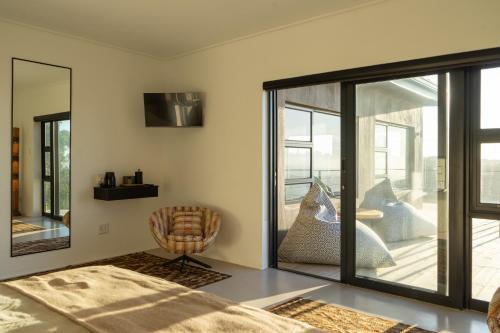 a bedroom with a large window and a chair at Views over Wilderness in Wilderness