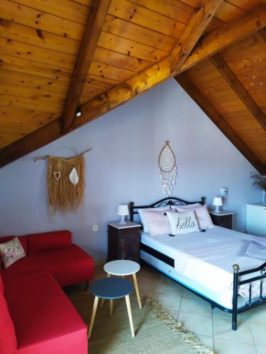 a bedroom with a bed and a red couch at Evelina 3 in Lixouri