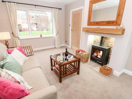 a living room with a fireplace and a couch at Willows in Corbridge