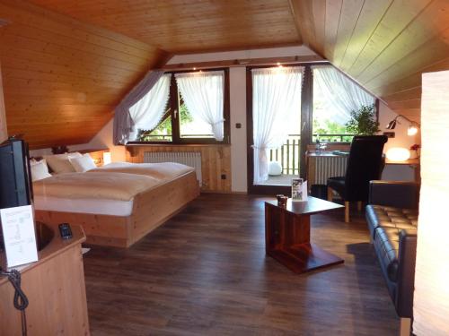 Landhotel Mühle zu Gersbach في Gersbach: غرفة نوم مع سرير وغرفة معيشة