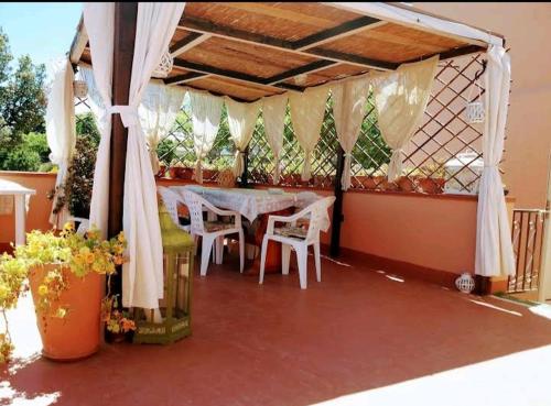 a patio with a table and chairs and plants at Belli come il Sole in Serri