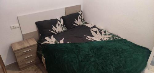een slaapkamer met een bed met een groen dekbed bij Casa Gilda in Torrevieja