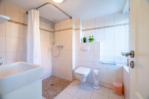 een badkamer met een toilet, een bad en een wastafel bij Amelie in Zingst