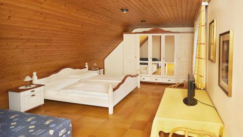 メルビッシュ・アム・ゼーにあるGästezimmer Helga Sommerの白いベッドと木製の天井が備わるベッドルーム1室が備わります。
