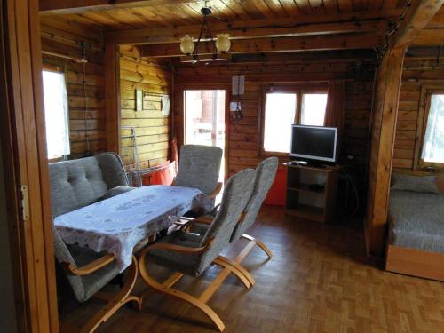 a living room with a table and chairs in a cabin at Ośrodek Wczasowy Słoneczna Polana in Poddąbie