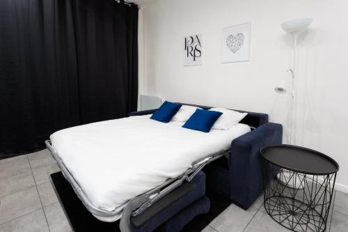 a large bed with blue pillows in a room at Rare! private garden in Paris, close to Sacre Coeur Basilica! in Paris