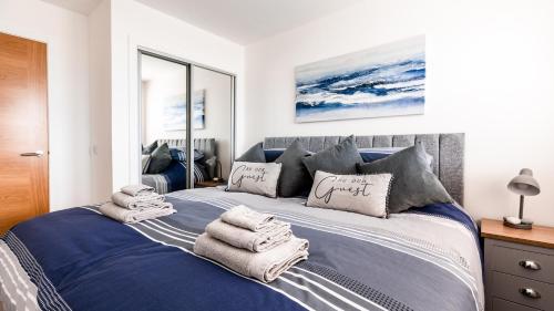 a bedroom with a blue bed with towels on it at Jules By The Sea Anstruther in Anstruther