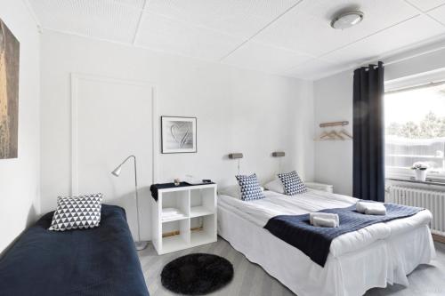a white bedroom with two beds and a window at Aurora Bed & Breakfast in Simrishamn