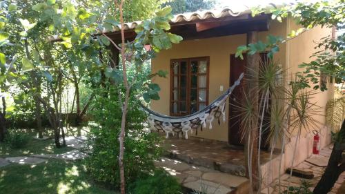 a house with a hammock in the yard at Chalé Juliet in Pirenópolis