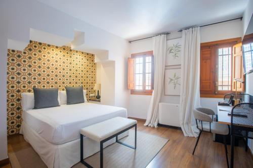 um quarto com uma cama branca e uma secretária em Soho Boutique Atalia em Córdoba