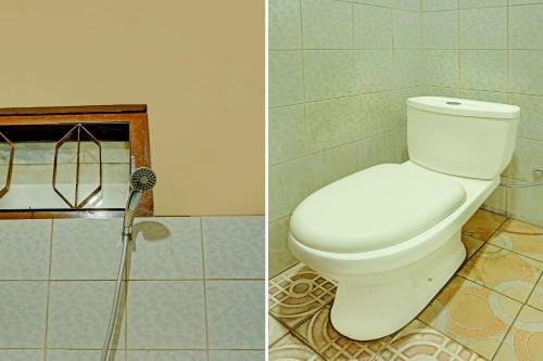 a bathroom with a white toilet and a shower at SPOT ON 92450 Homestay Simpang Panji Suroso Syariah in Malang