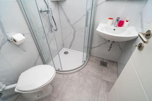 a bathroom with a shower and a toilet and a sink at Guest House Daniela in Mlini