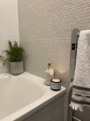 a bathroom with a white sink with a plant on it at Shoreditch Cosy Flat, next to Van Gogh exhibition in London
