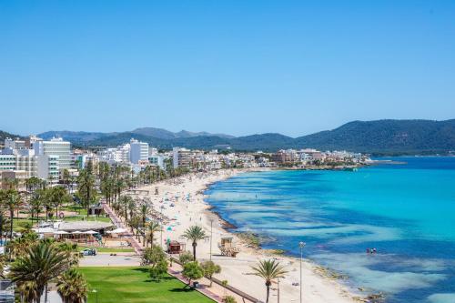 a view of a beach with palm trees and the ocean at Apto con Terraza 102 in Cala Millor