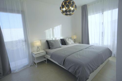 um quarto branco com uma cama grande e janelas em Villa Patricia Playa Blanca em Playa Blanca