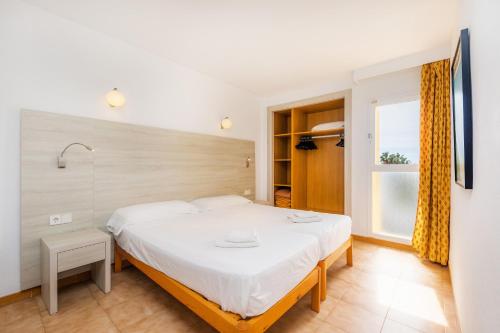 sypialnia z dużym łóżkiem i oknem w obiekcie Apto con Terraza 103 w Cala Millor