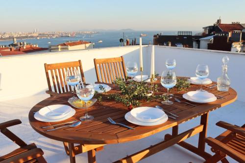 a wooden table with wine glasses and plates on it at Cihangir VAV Suites in Istanbul