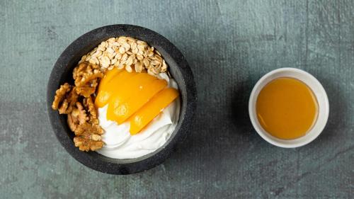 a bowl of food with a bowl of fruit and a cup of coffee at The Newel Psychiko in Athens