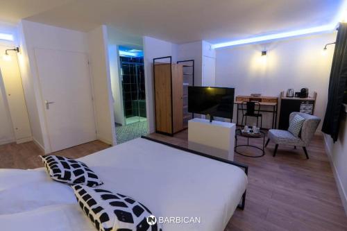 a bedroom with a large white bed and a television at Barbican in Villars-les-Dombes