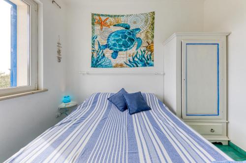 ガリアーノ・デル・カーポにあるNovaglie Mon Amourのベッドルーム1室(青と白のベッド1台、絵画付)