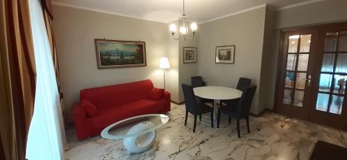 salon z czerwoną kanapą i stołem w obiekcie Appartamento Sestri Levante Al Mare w mieście Sestri Levante