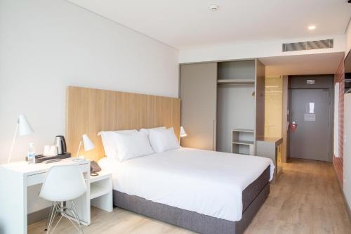 um quarto de hotel com uma cama e uma secretária e um quarto em Stay Hotel Porto Aeroporto em Maia