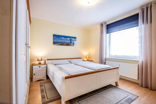 1 dormitorio con cama y ventana grande en Haus Seemeile Wohnung 2 20, en Büsum