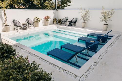 a swimming pool with blue chairs and a swimming pool at Pousada Villa Santô in Guarujá