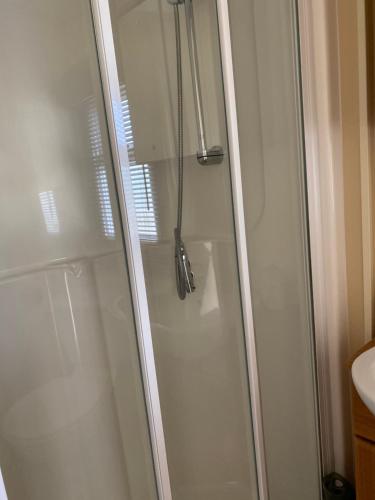 a shower with a glass door in a bathroom at Croft View in Taynuilt