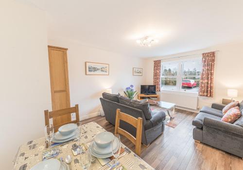 a living room with two couches and a table at Tiggs Place, 5 Howrahs Court in Keswick