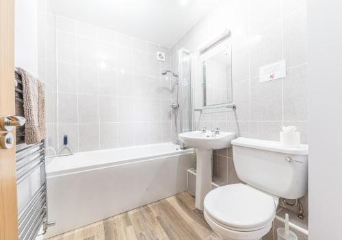 a white bathroom with a toilet and a sink at Tiggs Place, 5 Howrahs Court in Keswick