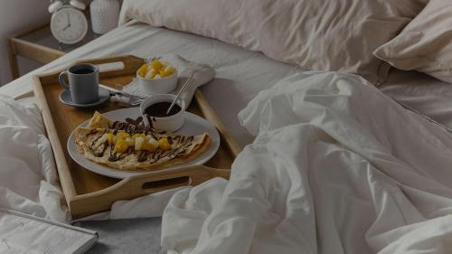 bandeja de desayuno con plato de comida en la cama en Rosa's House Bed and Breakfast en Santa Margherita di Belice