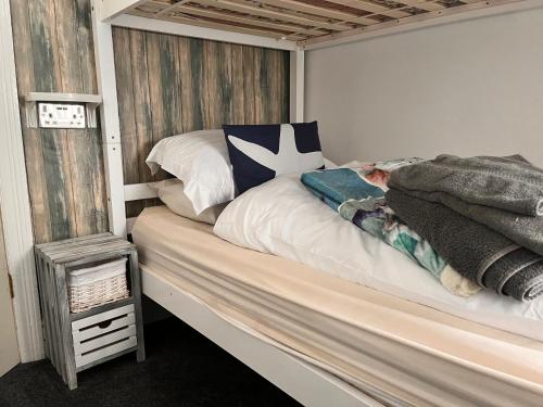 a bed with a wooden headboard in a bedroom at Chomley holiday flats in Scarborough