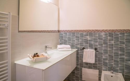 a white bathroom with a sink and a urinal at Hotel Aldiola Country Resort in Sant Antonio Di Gallura