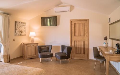 a bedroom with chairs and a desk and a bed at Hotel Aldiola Country Resort in Sant Antonio Di Gallura