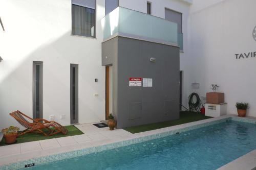 a house with a swimming pool next to a building at Luxury Townhouse, in Tavira Centre with shared pool in Tavira