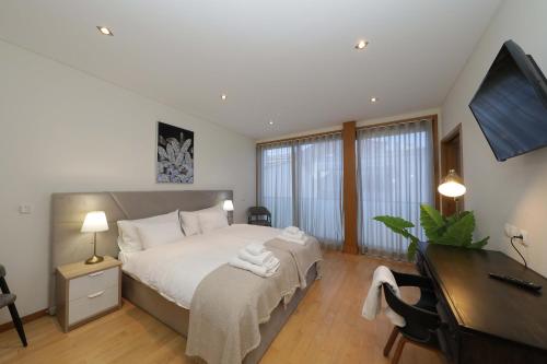 1 dormitorio con cama, escritorio y escritorio en Luxury Townhouse, in Tavira Centre with shared pool, en Tavira