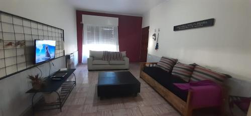 uma sala de estar com um sofá e uma televisão em El sueño em San Rafael