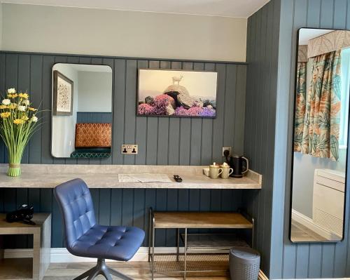 a blue bathroom with a vanity and a blue chair at The White Horse Hotel and Luxury Shepherds Huts in Eye