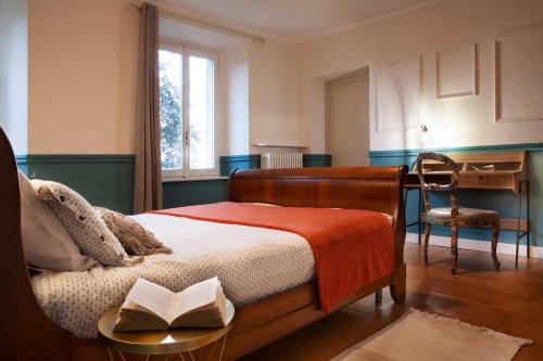 Un dormitorio con una cama con un libro. en Como Lake Panorama Apartment Sveva en Cernobbio