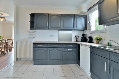 - une cuisine avec des armoires bleu foncé et un évier dans l'établissement La Ruelle Secrète, à Plurien