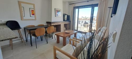 salon ze stołem i krzesłami oraz kominkiem w obiekcie Casa Clare, Cabo Roig w mieście Cabo Roig