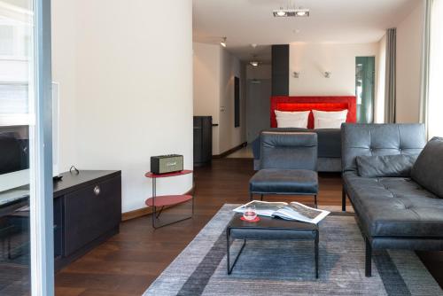 uma sala de estar com um sofá e uma cama em niXe Boutiquehotel & Spa em Binz
