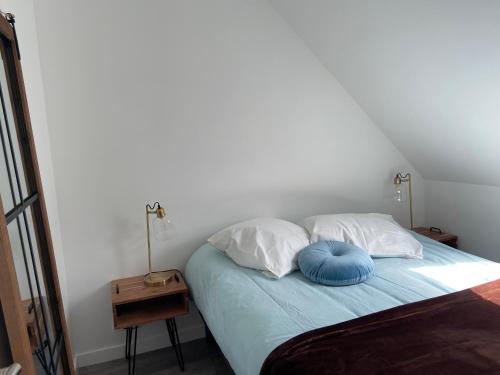 a bedroom with a bed with two pillows on it at Ty Eurvad - Proche des plages in Bangor