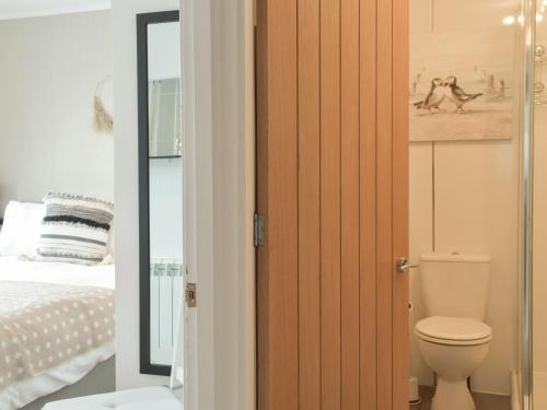 a bathroom with a toilet next to a bed at Bell Tower B in Berwick-Upon-Tweed