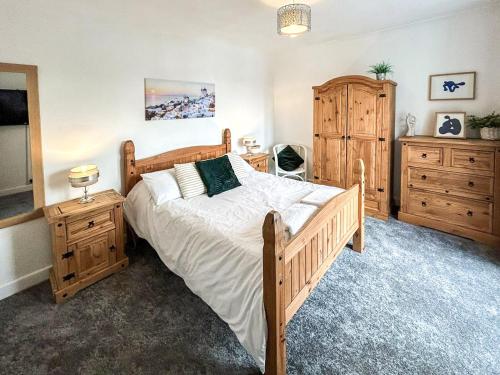 una camera con un grande letto e mobili in legno di Highcross a Poulton-le-Fylde