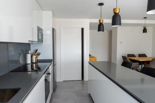 uma cozinha com armários brancos e um balcão preto em Amazing 3 bedroom apartment Cala Serena La Cala de Mijas em La Cala de Mijas
