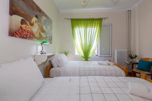 a hotel room with two beds and a window at Casa Loula in Corfu