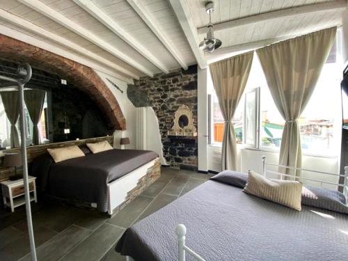 a bedroom with two beds and a brick wall at 5 TERRE PELAGOS 2 in Manarola