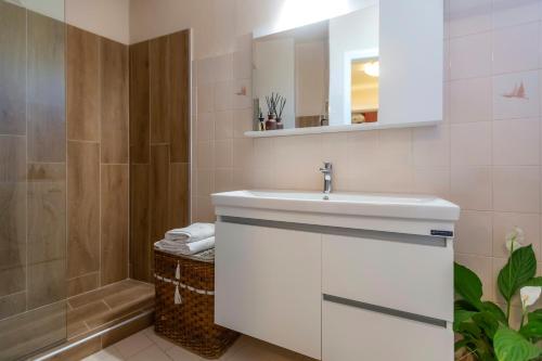 een badkamer met een witte wastafel en een douche bij Casa Loula in Corfu-stad
